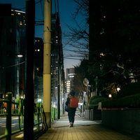 街灯に照らされた夜道を歩くランドセルを背負った児童の夜廻りの写真