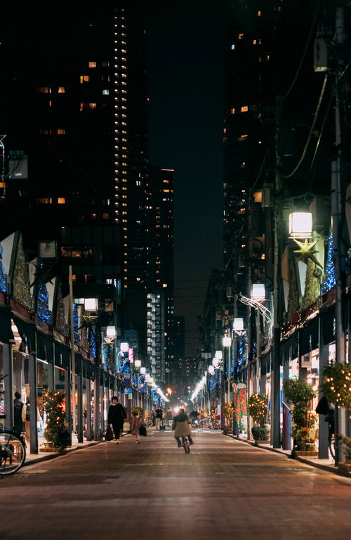 日が暮れた月島西仲通り商店街の街灯に照らされた夜景