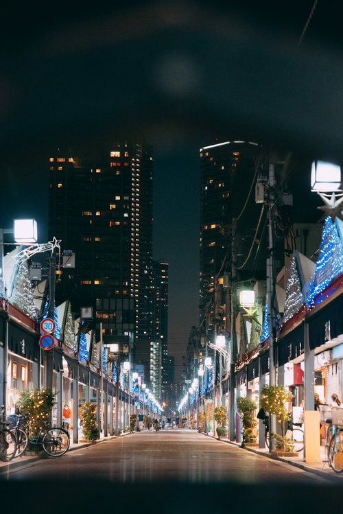 日が落ちた月島商店街の街灯が灯る夜景と店舗