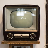 木製ケースの白黒アナログテレビ、ブラウン管と操作ダイヤルの写真