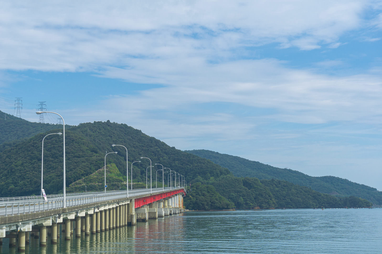 小浜湾の青い海にかかる白い海上橋と緑の山々