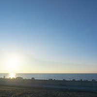 海釣りを楽しむ人々と沈む太陽の写真