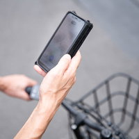 自転車で次の配達先をスマホの地図で調べる配達パートナーの写真