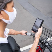 スマートフォンで配達先を確認する配達パートナーの男性の写真