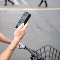 スマートフォンの地図アプリで配達先をチェックする配達パートナーの写真