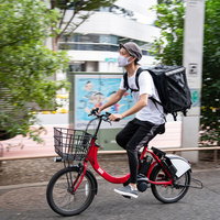 赤い自転車で配達するフードデリバリーの男性の写真