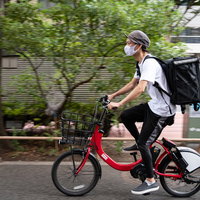 目的地（配達ポイント）に向かうフードデリバリーの配達員の写真