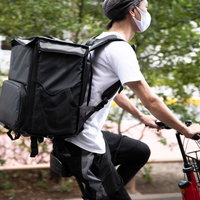 回数インセンティブ中のフードデリバリー配達員が赤チャリで運転の写真