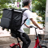街中でよく見かける赤チャリ配達員の配達風景の写真
