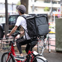 フードデリバリーの配達員さんが自転車で走るの写真
