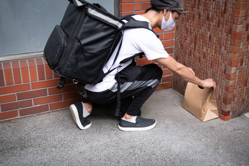 地べたに置き配するフードデリバリーの配達員さん