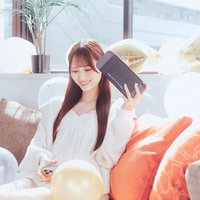 ソファでくつろぐ女性とカラフルなバルーンのある部屋の写真