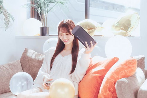 ソファでくつろぐ女性とカラフルなバルーンのある部屋