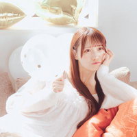白いバルーンとソファーでくつろぐ赤褐色髪の女性の写真
