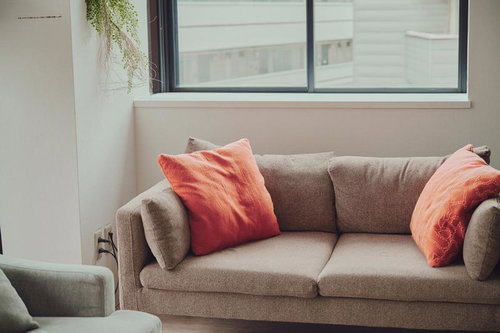 自然光が差し込むモダンなソファー空間にコーディネートされたクッション