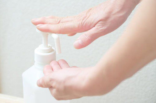 白いボトルのプッシュポンプで手を消毒する場面