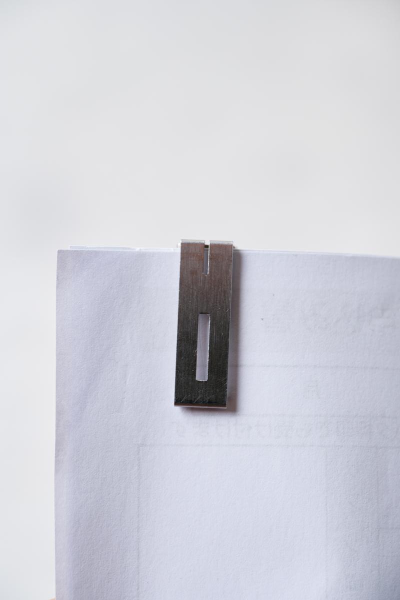 白い用紙に留められた木製の茶色いクリップ