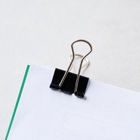 用紙を留めた黒いバインダークリップの書類整理の写真