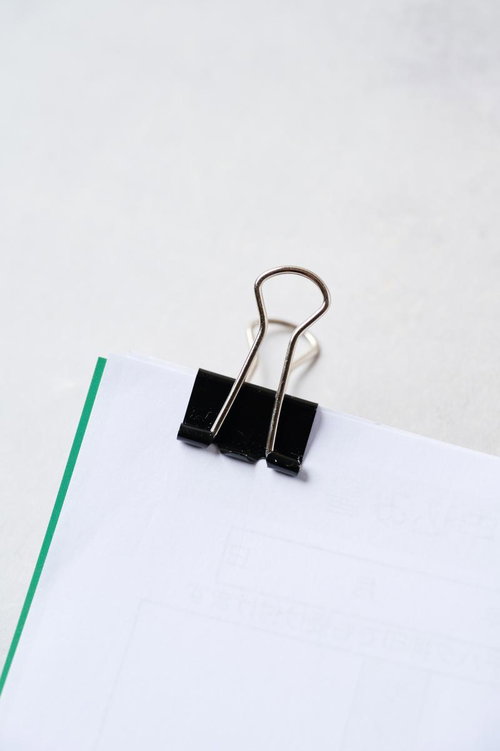 用紙を留めた黒いバインダークリップの書類整理