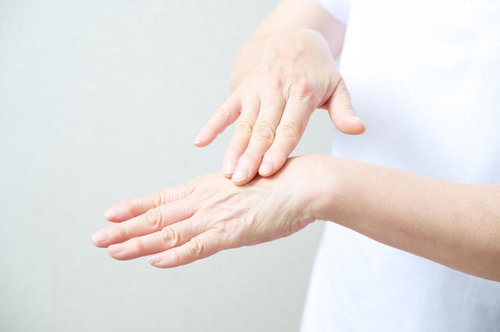 手の甲に保湿クリームを塗る女性のハンドケアシーン