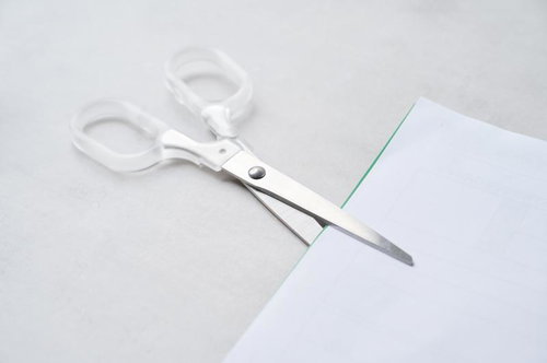 白いハサミで用紙を切る様子
