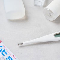 デジタル体温計と常備薬が置かれた医療キットの写真