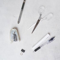 デスクに広げた筆記用具と文具セット、カッターやハサミなどの写真