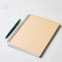 クリーム色のスパイラルノートと紺色ボールペンの写真