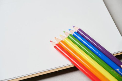 カラフルな色鉛筆が並ぶ白いノートの上の