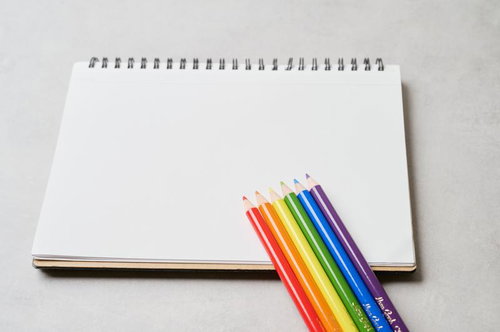 カラフルな色鉛筆が並ぶ白いスケッチブック