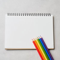 虹色の色鉛筆が並ぶスケッチブック - カラフルな画材のの写真