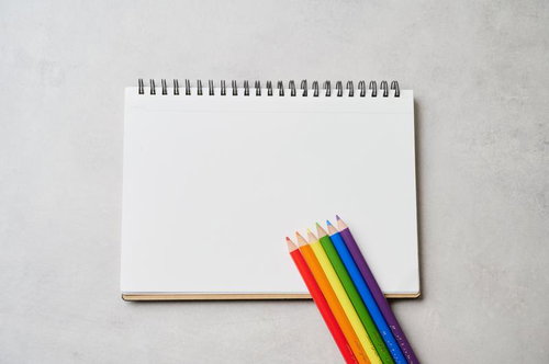 虹色の色鉛筆が並ぶスケッチブック - カラフルな画材の