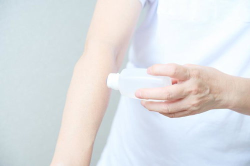 自分の腕に虫刺されのかゆみ止めローションを塗る