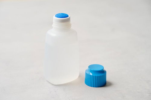 スポンジヘッドの透明ボトルと青いキャップの塗布容器