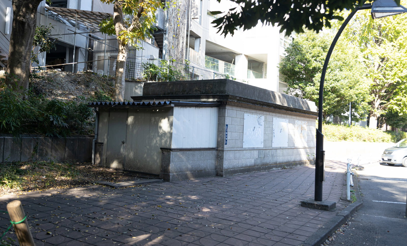 木々に囲まれた旧博物館動物園駅のコンクリート製駅舎