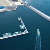 上空から撮影した請戸漁港の漁船と防波堤の港湾風景の写真