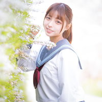 白い花に囲まれて微笑む女子高生の写真