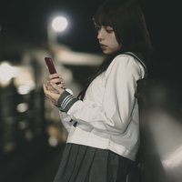 待ち合わせ場所でスマートフォンを確認する女子高生の写真