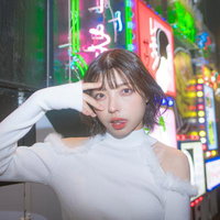 ネオン看板が輝く繁華街での夜遊び女子の夜間風景の写真