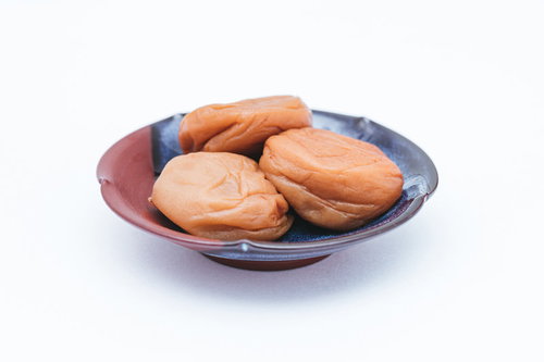 濃い紫色のお皿に盛られた潰れた梅干しの