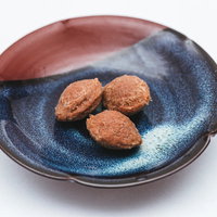 陶器の皿に盛られた梅干しの種3つと実、和食の定番食材の写真