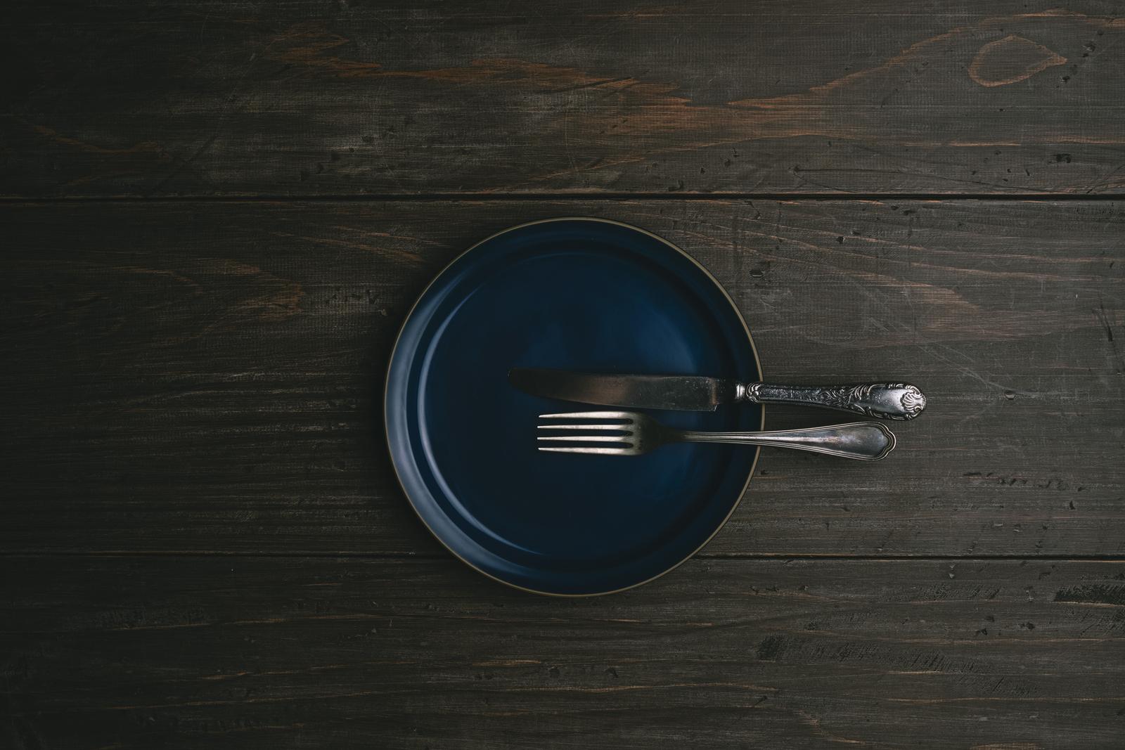 濃紺のプレートに置かれたシルバーのナイフとフォーク