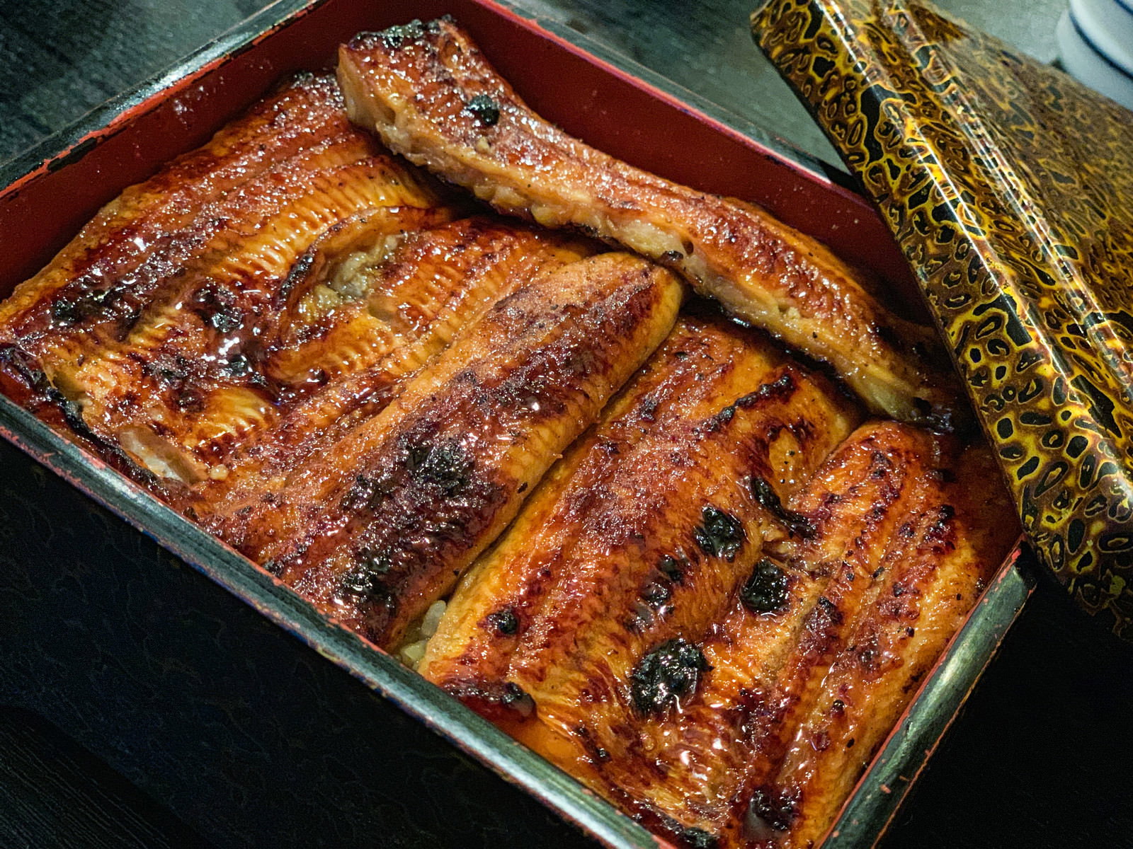 Deliciously grilled unagi don arranged in a jubako