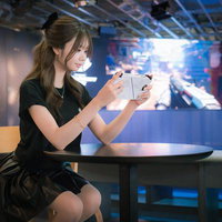 携帯型ゲーミングPCでゲームをプレイする女性の写真