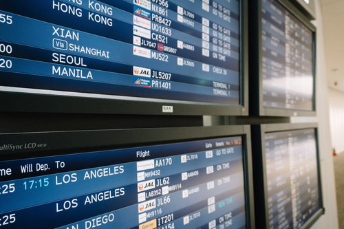 空港の電光掲示板に表示される海外行きフライト情報