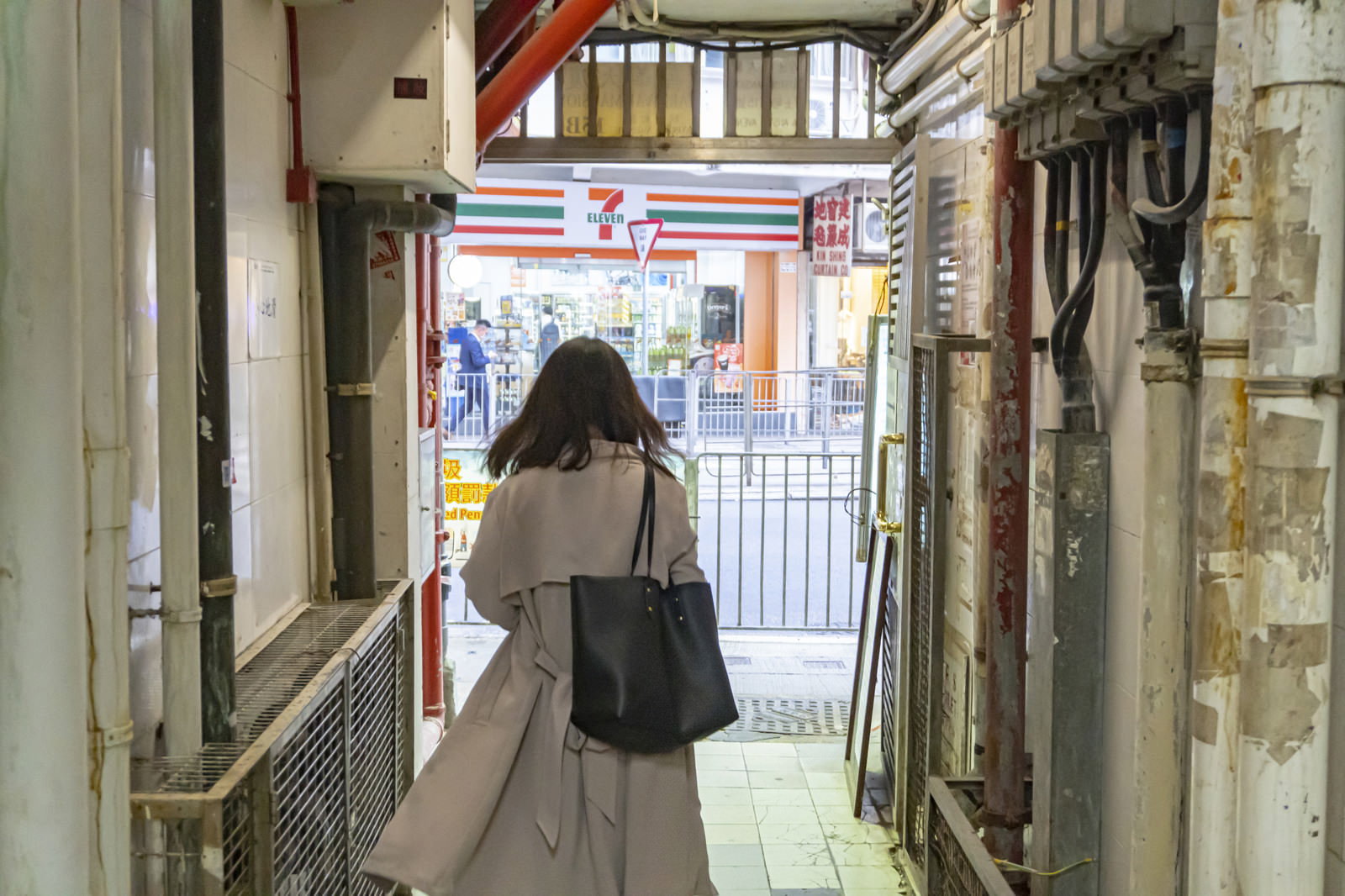 香港の雑居ビルから出てくる女性の後ろ姿
