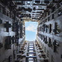 日が当たりにくい香港の雑居ビルを下から見上げた構図の写真