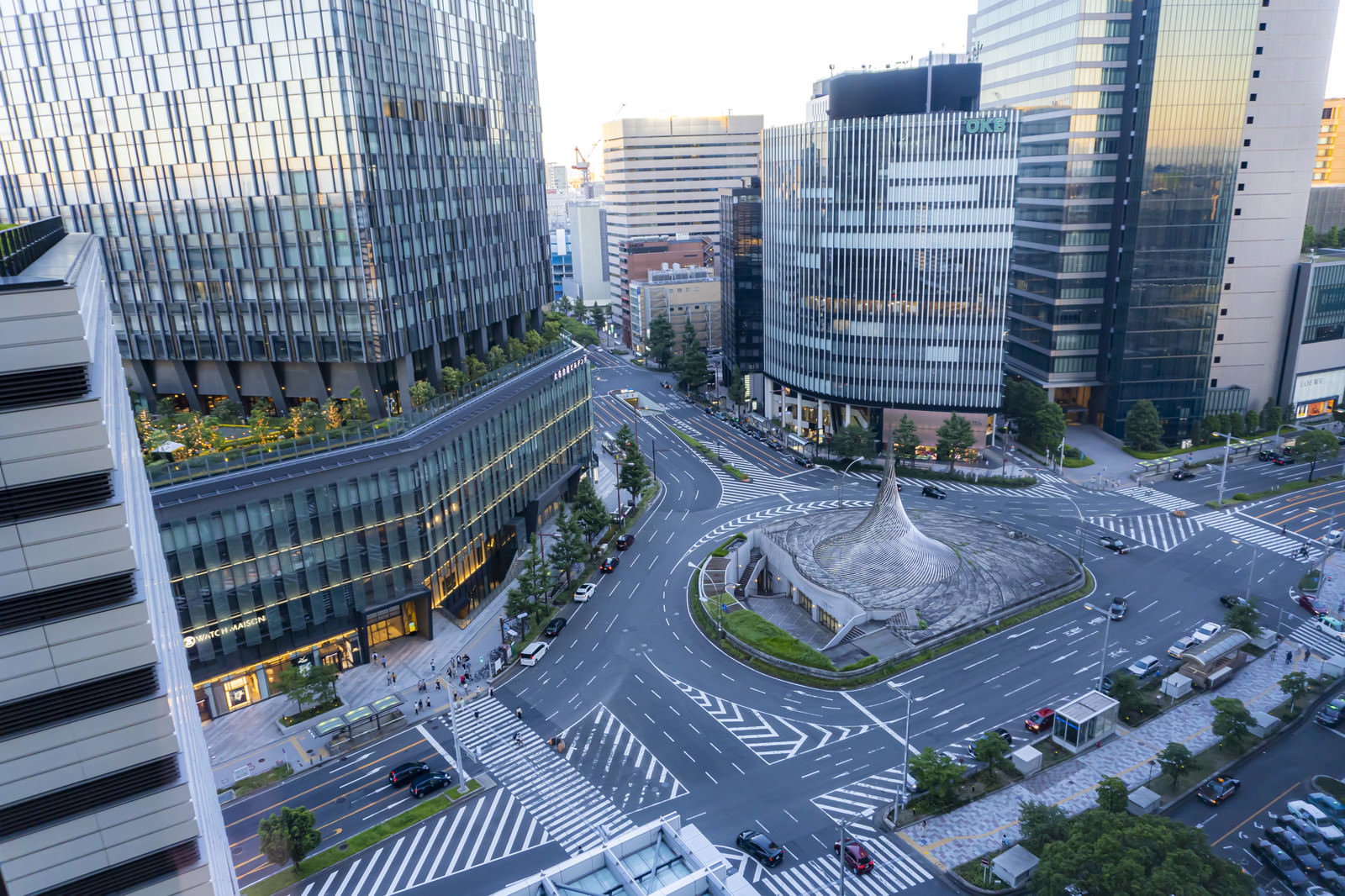 名古屋駅東口の広場にそびえる白い円錐状のモニュメント「飛翔」と周囲の高層ビル