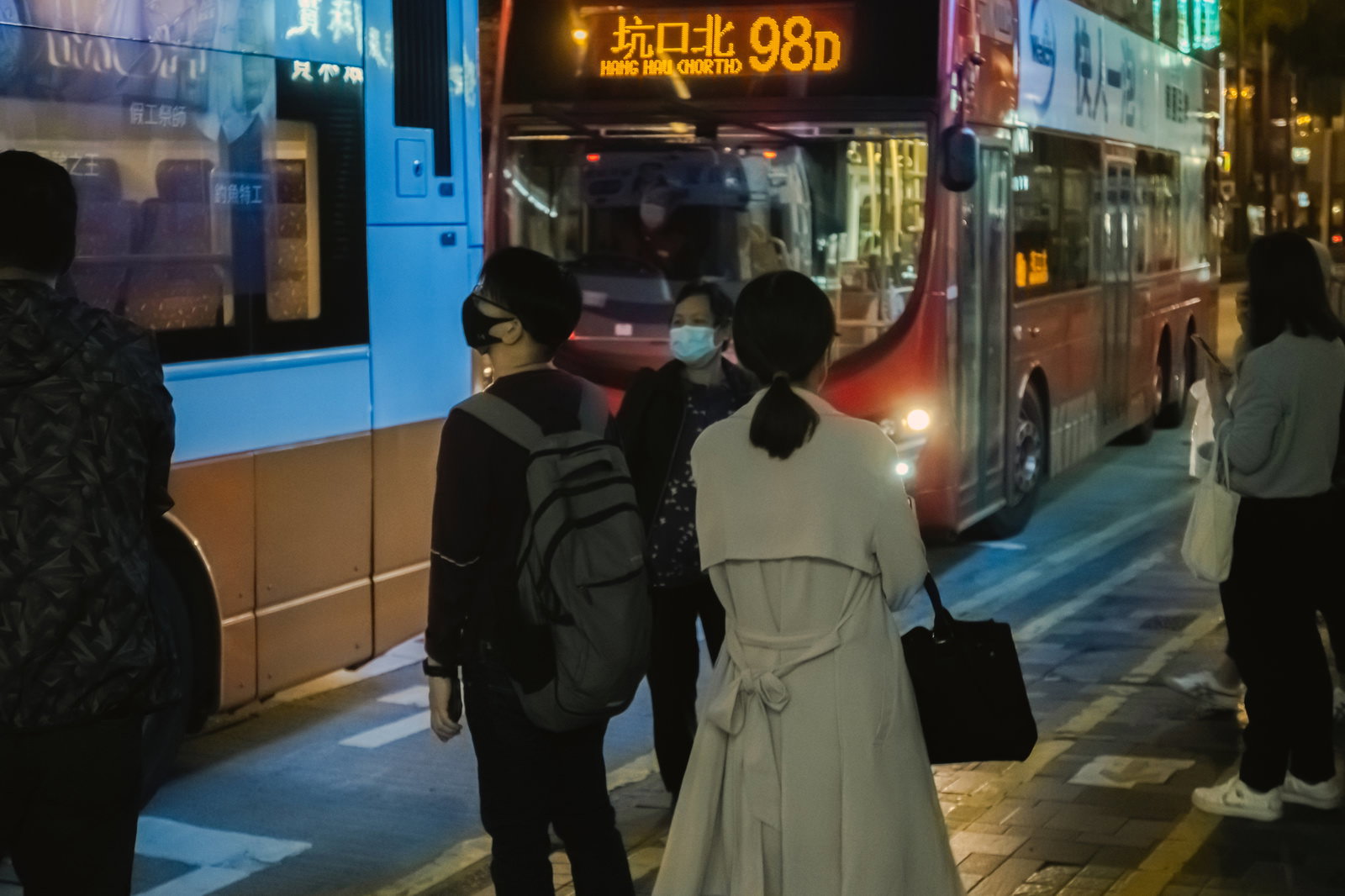 バス停でバスを待つ仕事帰りのOLたち