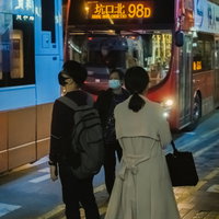 バスで帰る仕事帰りの香港OLたち、バス停での待機風景の写真